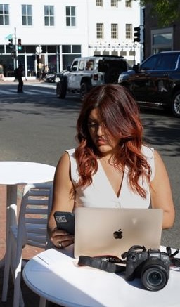 Woman working on laptop at outdoor cafe